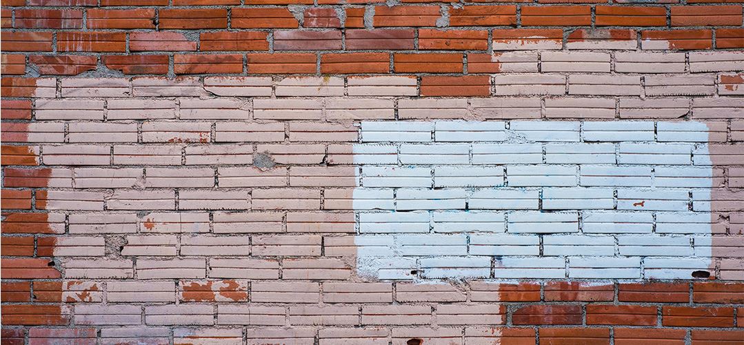 Brick wall with painted areas from covering up grafitti